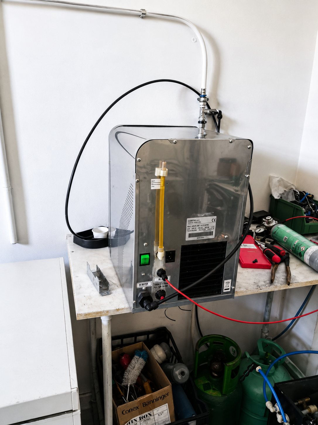 Refrigeratore in officina, aperto sul banco di riparazione con manometri e bombole